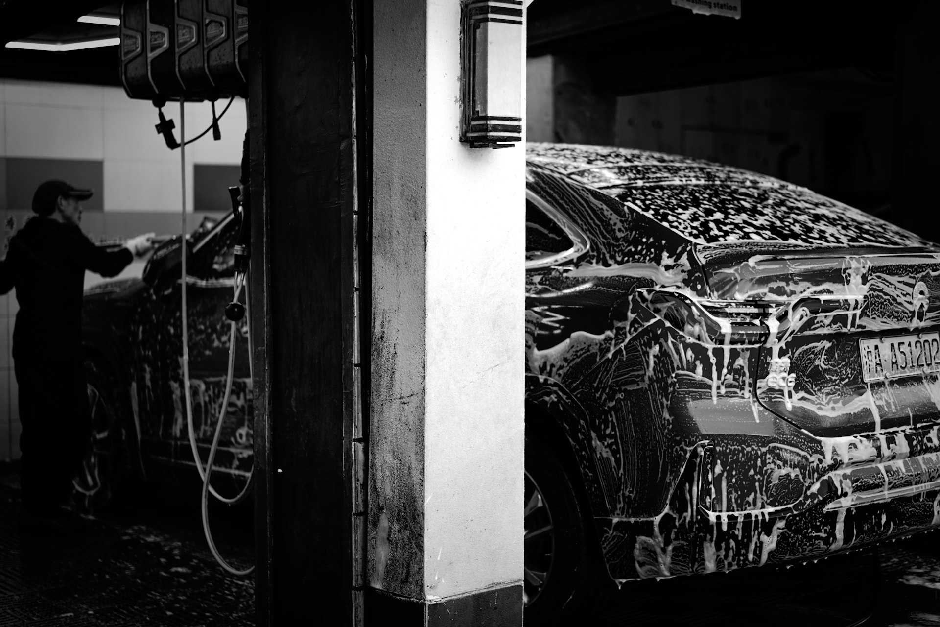 a man washing a car in a garage